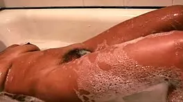 Chill with this teen in the bath as she fingers her hairy pussy.