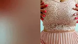 This pretty girl in pink dress plays with her huge natural tits at home!