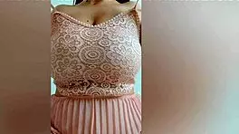 This pretty girl in pink dress plays with her huge natural tits at home!