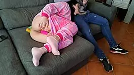 The cute babe sucks her boyfriend's friend on the sofa while he plays GTA