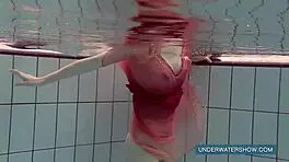 Katya okuneva bathes in pool wearing red dress