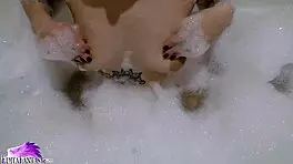 Feeling horny, cute babe sloppily sucks huge dildo in foamy bath close-up