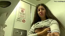 Skinny brunette masturbates riskily in airplane toilet without panties, nearly caught while cumming