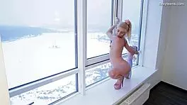 Sexy blonde gymnast Mischele Lomar shows off flexibility on sofa.