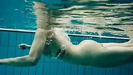 Dashka enjoys a beautiful swim in the pool, going from bikini to naked underwater.