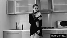 This skinny redhead covers herself in oil and masturbates in the kitchen, fingering to orgasm