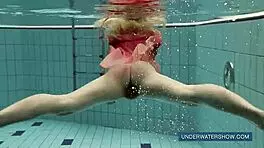 katya okuneva steps into the pool in a red dress, enjoying the outdoor beach scene underwater