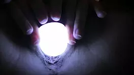 Sleepless girl rubs her trimmed clit under handheld light at night.