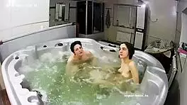 Young lesbian couple bathes intimately, fingers exploring in jacuzzi