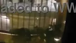 Milf masturbates in front of hotel window.