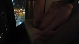 Milf masturbates in front of hotel window.
