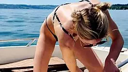 blonde housewife washes boat in sexy thong swimsuit for summer fun.