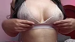 In the bedroom, horny lesbian with big natural tits and erect nipples uses toys.