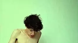 On a sunny day, this horny young teen masturbates with a big cock on the bed, getting cum covered.