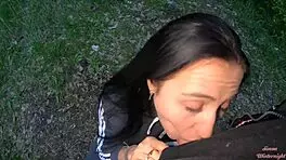 Brunette teen girlfriend gives wet sloppy blowjob with cum in mouth to big cock friend in evening park outdoors