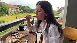 Enjoying a mouthful of pizza on the street in a public cafe with beautiful teen