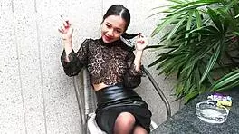 Young girl smokes topless in leather skirt
