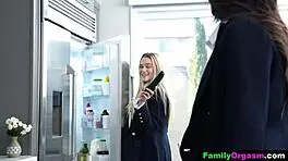 School sisters playing with a big cucumber in the kitchen