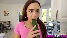 Young girl sucks cucumber before blowing older man