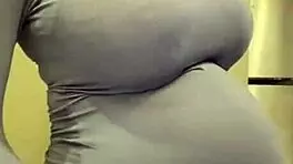 The pregnant woman pulls her milky tits out of her red bra