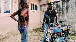 Petite biker babe stands on bike taking hard public garage fuck from man!